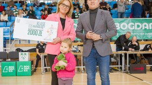 dyrektorka przedszkola trzyma kartkę z napisem 2000zł - kwota wygranej w programie zabierz klasę na ekstraklasę AZS UMCS Lublin