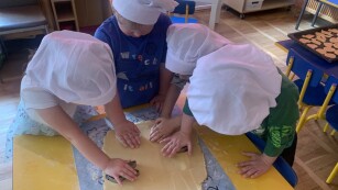 dzieci wykrawają kształty ciastek